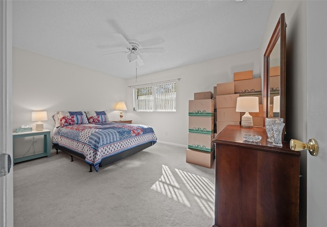 bedroom featuring ceiling fan, light carpet, and a textured ceiling