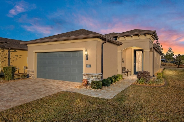 view of front of home with a garage and a yard