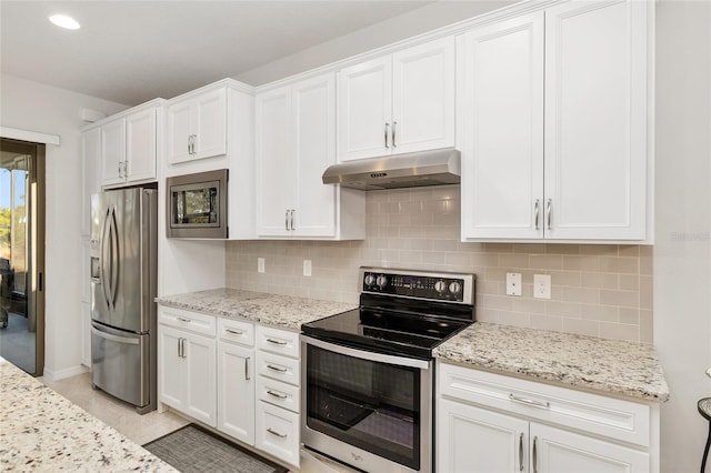 kitchen featuring stainless steel appliances, backsplash, white cabinetry, and light stone countertops