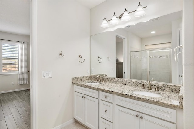 bathroom with hardwood / wood-style floors, a shower with door, and vanity