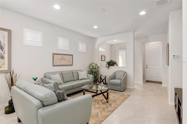 tiled living room featuring a textured ceiling