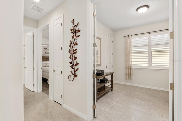 hall with a textured ceiling