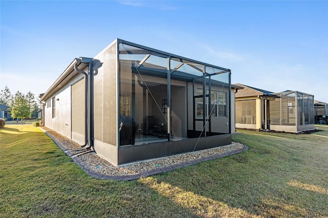 rear view of property featuring glass enclosure and a yard