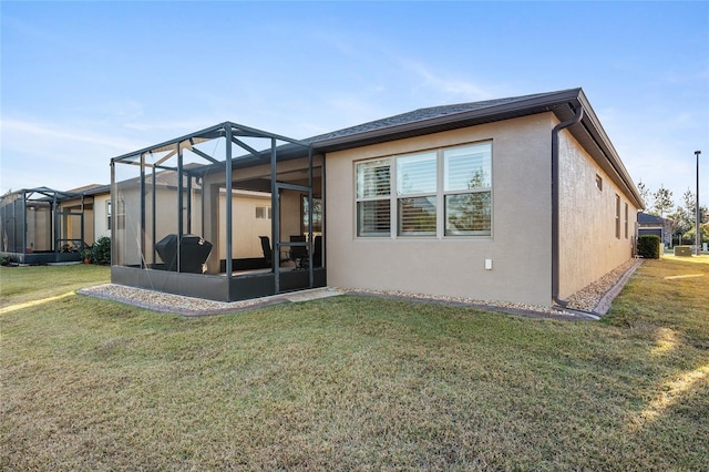 rear view of house featuring a lawn and a lanai