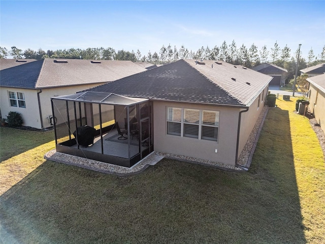 back of house featuring glass enclosure, a yard, and a patio