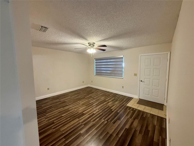 unfurnished room featuring ceiling fan, dark hardwood / wood-style floors, and a textured ceiling