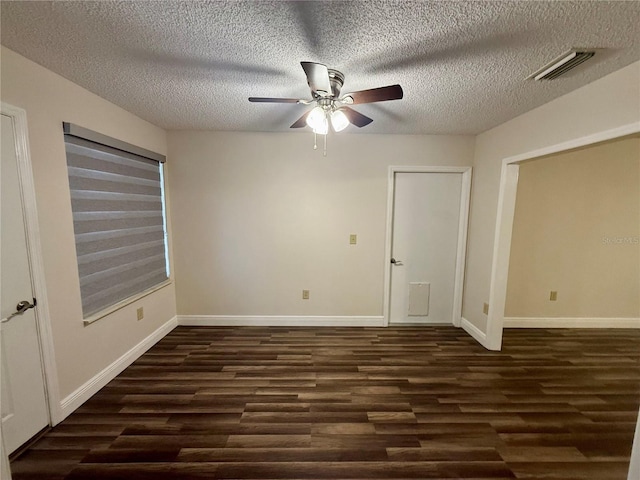 empty room featuring a textured ceiling and dark hardwood / wood-style floors