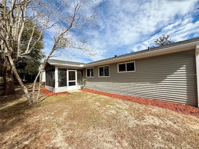 rear view of property featuring a sunroom