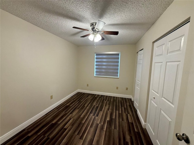 unfurnished bedroom with ceiling fan, dark wood-type flooring, and a textured ceiling