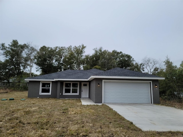 single story home with a garage and a front lawn