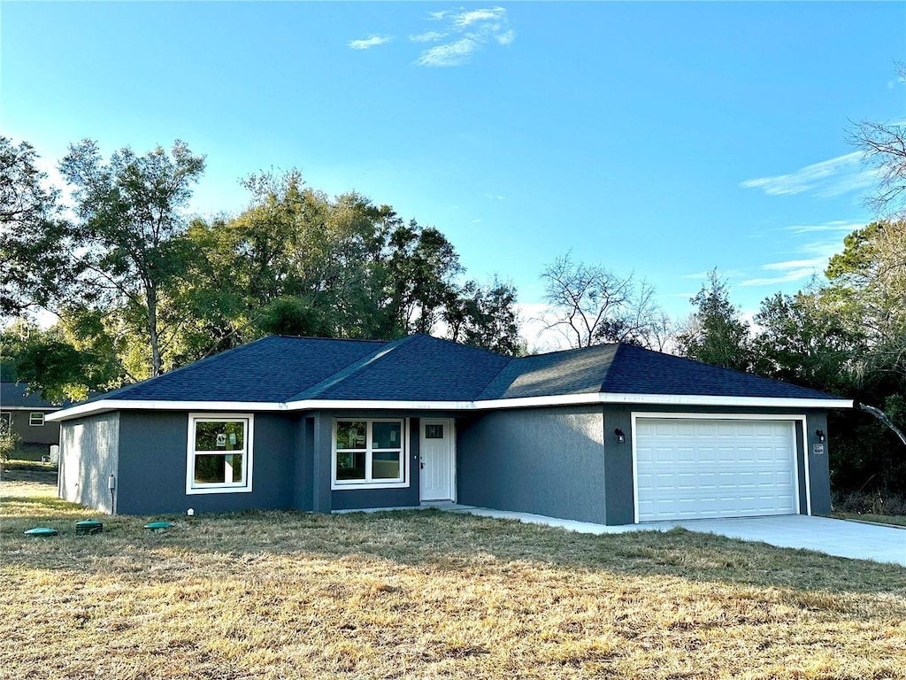 single story home with a garage and a front lawn