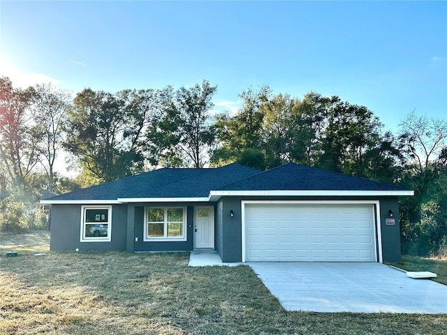 ranch-style home featuring a garage and a front lawn