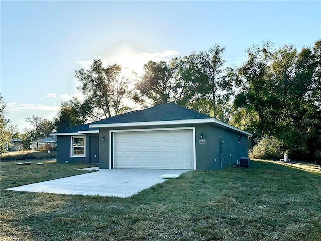 garage with central AC unit and a lawn