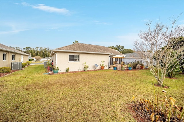 rear view of property with a lawn and central AC unit