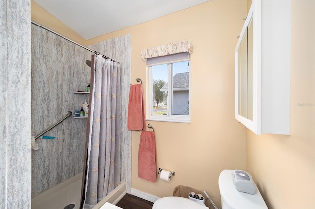 bathroom with toilet and a shower with curtain