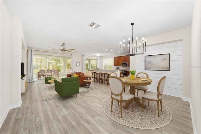 dining space with ceiling fan and light wood-type flooring