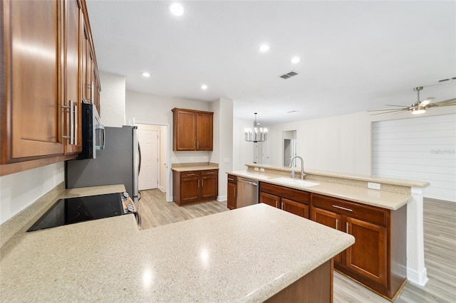 kitchen featuring light hardwood / wood-style flooring, appliances with stainless steel finishes, sink, and pendant lighting