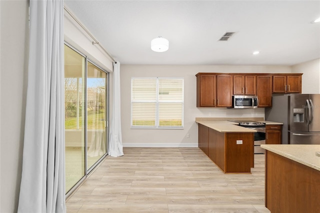 kitchen featuring kitchen peninsula, light hardwood / wood-style flooring, and stainless steel appliances