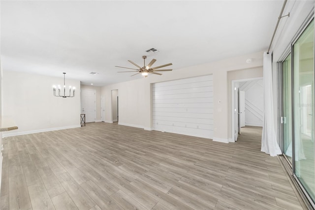 unfurnished living room featuring light wood-type flooring and ceiling fan with notable chandelier