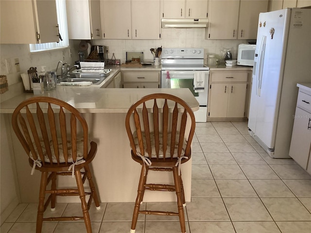 kitchen featuring light tile patterned floors, white appliances, white cabinets, and tasteful backsplash