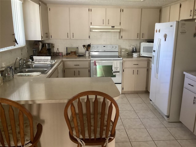 kitchen with white cabinets, sink, white appliances, and light tile patterned flooring