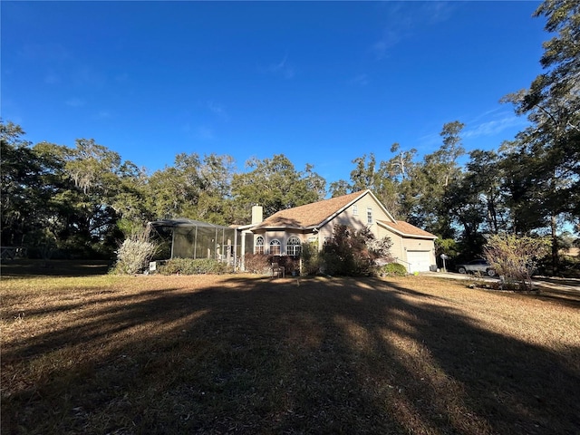 view of side of property featuring a garage and a lawn