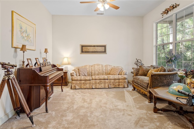 living area featuring light colored carpet and ceiling fan