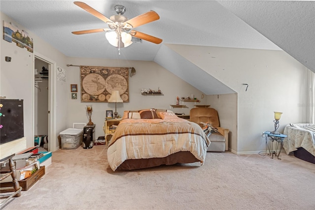 carpeted bedroom featuring vaulted ceiling, ceiling fan, a closet, and a textured ceiling