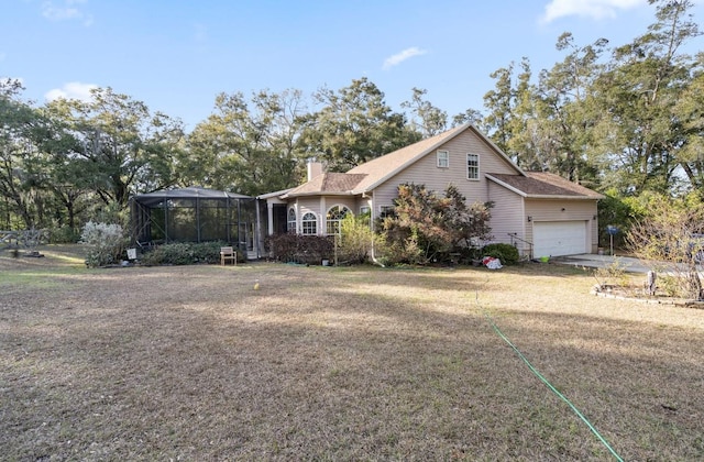 view of front of house with a garage, a front yard, and glass enclosure