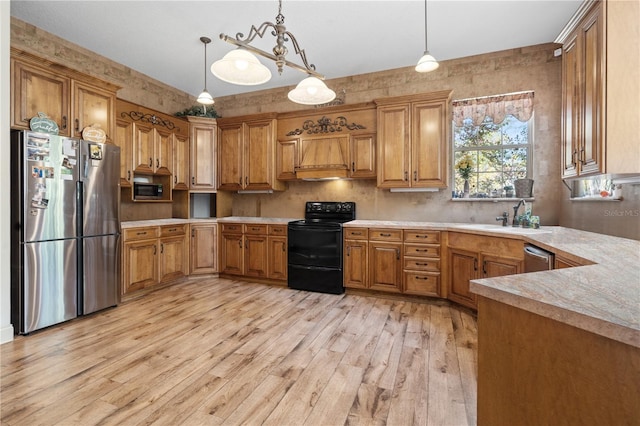 kitchen with hanging light fixtures, light hardwood / wood-style flooring, sink, and appliances with stainless steel finishes