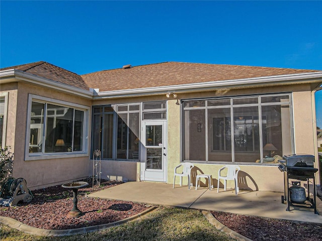 rear view of house featuring a sunroom and a patio area