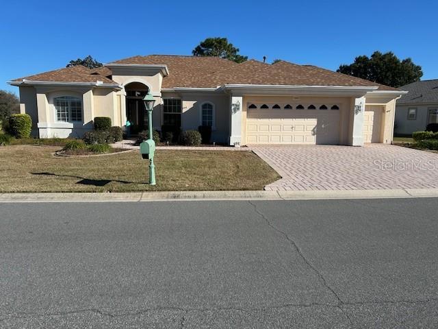 view of front of property featuring a garage and a front lawn