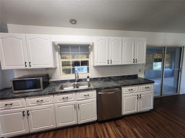 kitchen featuring tasteful backsplash, sink, white cabinetry, stainless steel appliances, and dark hardwood / wood-style flooring