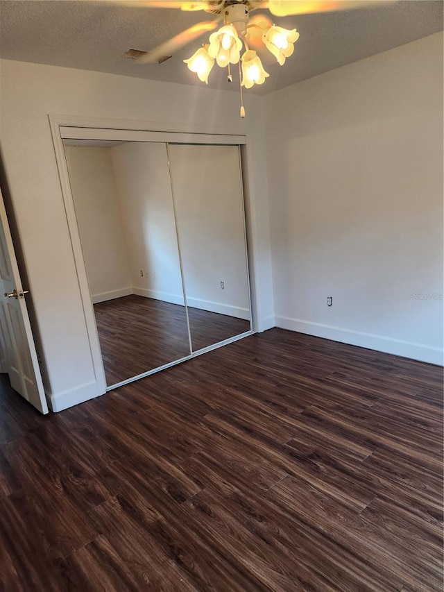 unfurnished bedroom with ceiling fan, a closet, and dark hardwood / wood-style flooring