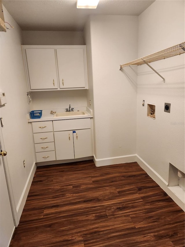 laundry area with sink, hookup for a washing machine, dark wood-type flooring, hookup for an electric dryer, and cabinets