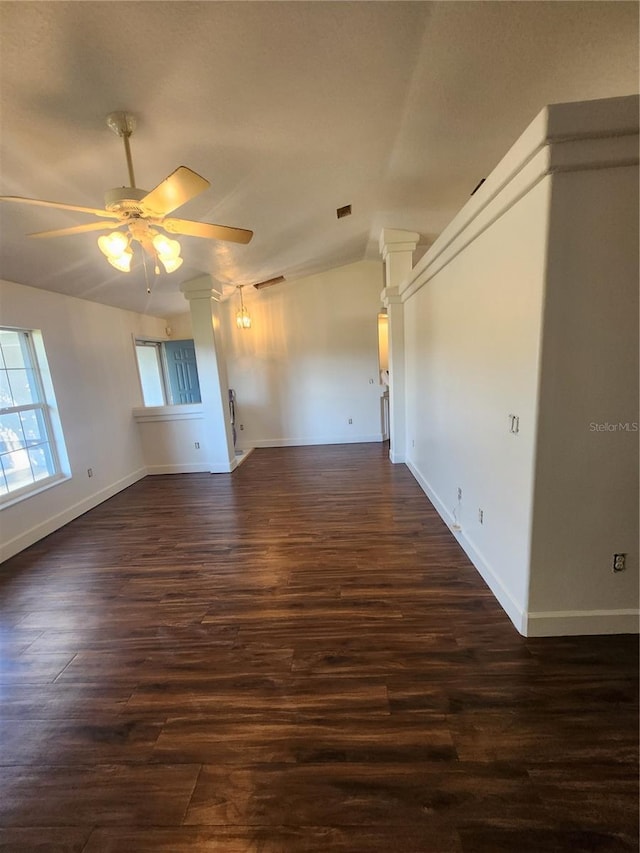 unfurnished room with ceiling fan, dark hardwood / wood-style floors, and ornate columns