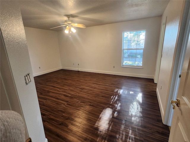 spare room featuring a textured ceiling, dark wood-type flooring, and ceiling fan