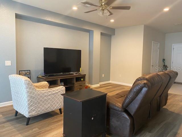 living room featuring ceiling fan and wood-type flooring