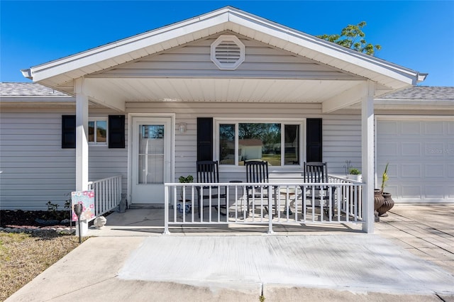 view of exterior entry with a garage and a porch