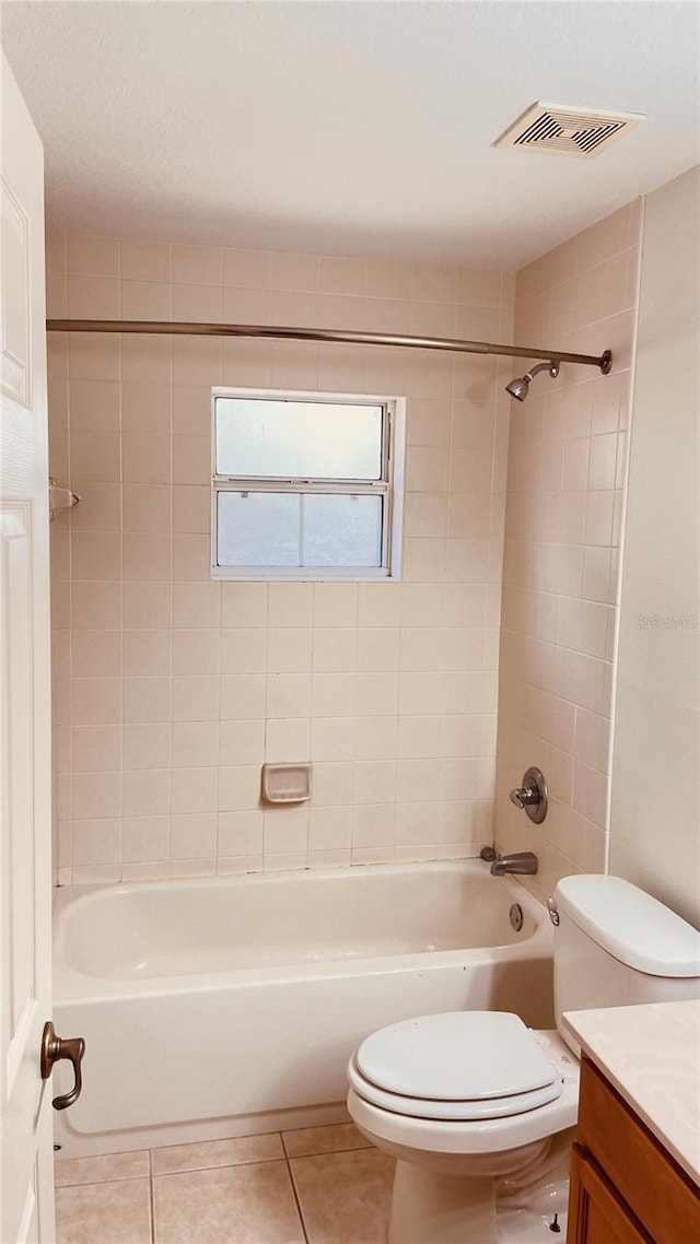 full bathroom with vanity, tiled shower / bath combo, tile patterned floors, and toilet