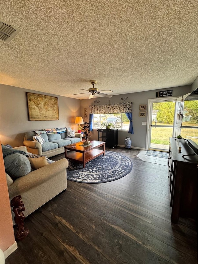 living room with a textured ceiling, ceiling fan, and wood-type flooring