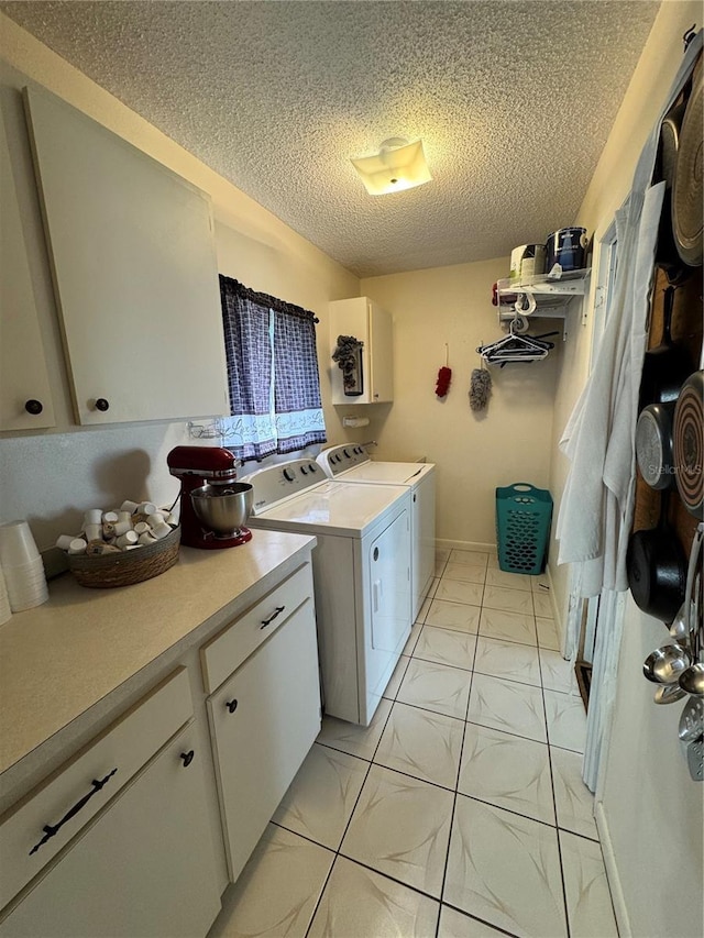 clothes washing area featuring washing machine and dryer, cabinets, light tile patterned floors, and a textured ceiling