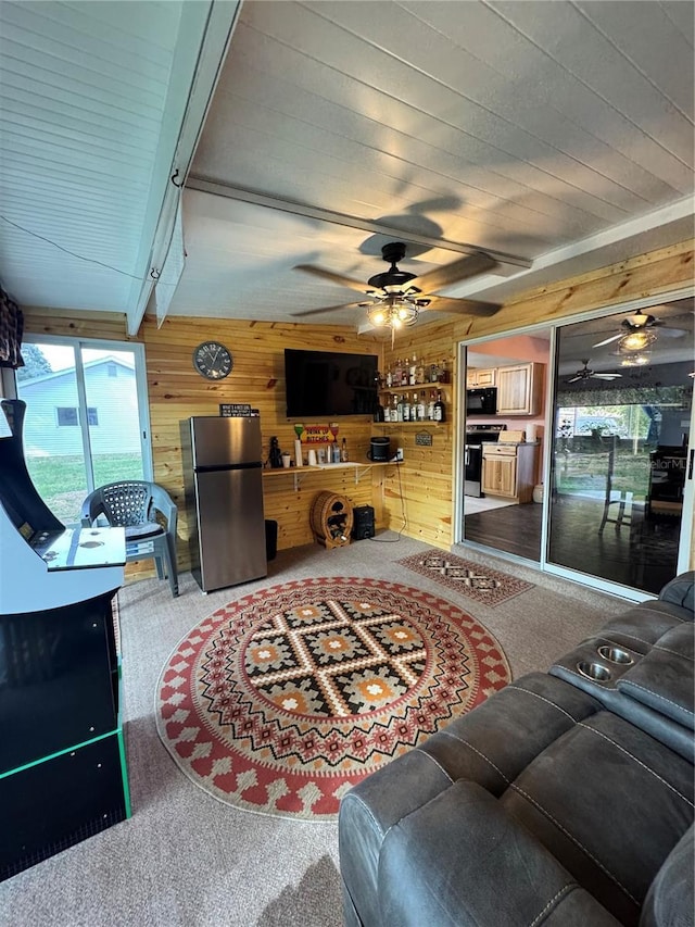 living room with beam ceiling, wood walls, and carpet flooring