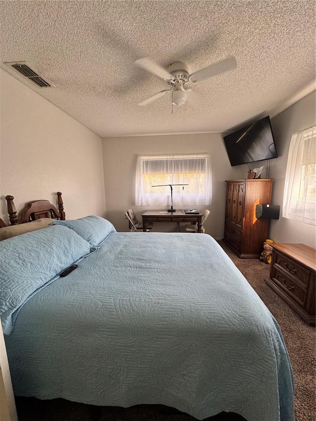 carpeted bedroom featuring a textured ceiling and ceiling fan