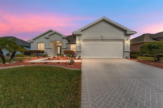 ranch-style house with a garage and a yard