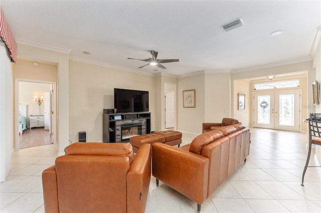 tiled living room featuring ceiling fan, ornamental molding, and french doors