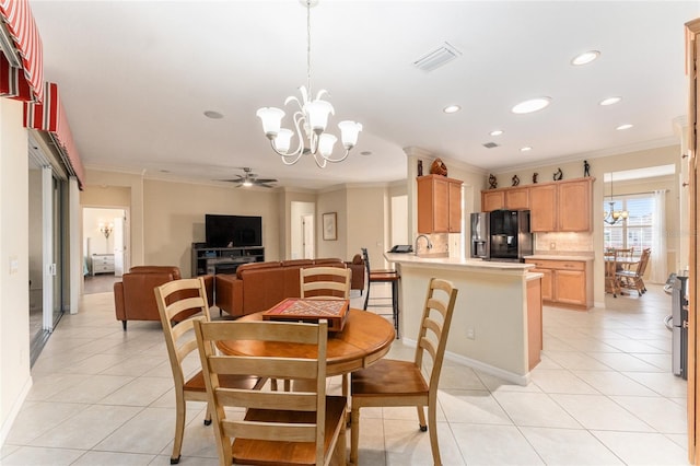 dining area with ceiling fan with notable chandelier, light tile patterned flooring, and crown molding