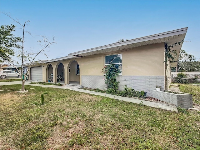 ranch-style home featuring a front lawn and a garage