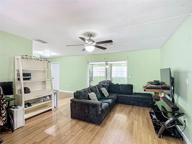 living room with ceiling fan and light hardwood / wood-style flooring