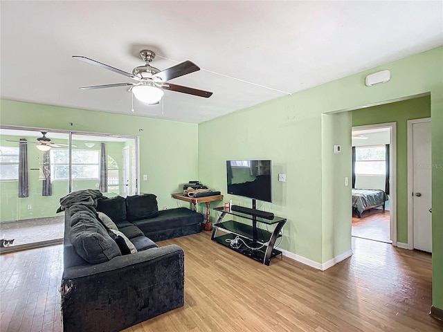 living room featuring light wood-type flooring and ceiling fan